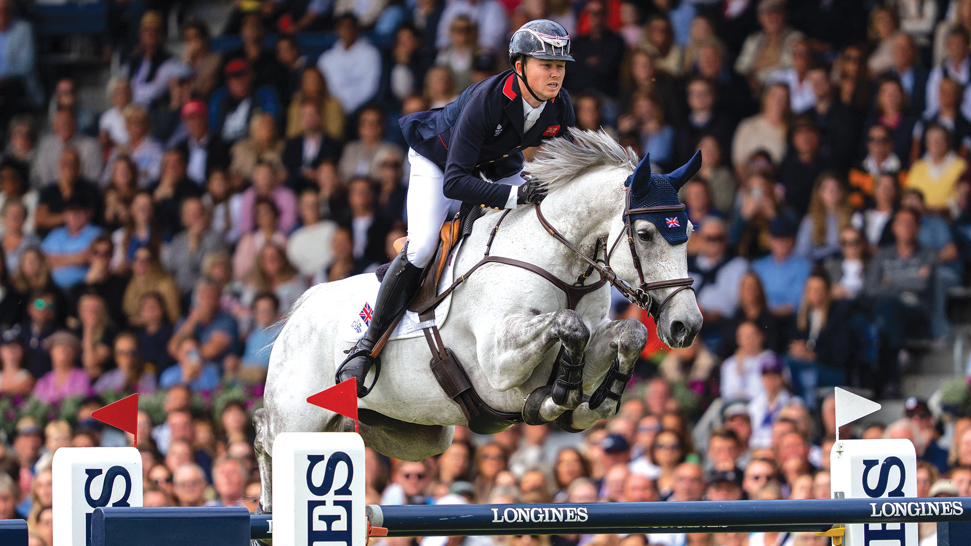 Harry Charles and LT Holst Freda clear a large Longines branded oxer in the Showjumping World Championships in Aachen 2026