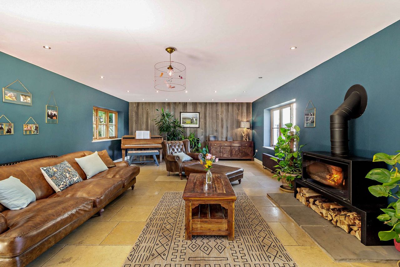 A living room with large fireplace and large leather sofa