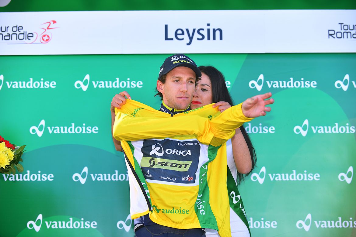 Simon Yates puts on his yellow jersey