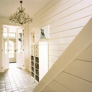 hallway with white horizontal striped wall and chandelier