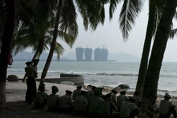 Hainan security officers relax beside the beach prior to the peloton raging into town in Sanya.