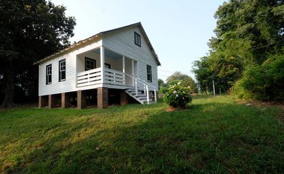white house on green grass at Nina Simone Childhood Home in Tryon, North Carolina