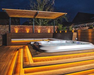 hydrolife hot tub sunk into decking with seating area and lighting