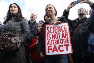 A woman holds a sign that reads, "Science is not an alternative fact" during the March for Science in Berlin, Germany.