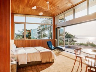 bedroom looking out towards the ocean through wide picture windows at the Surf House in california