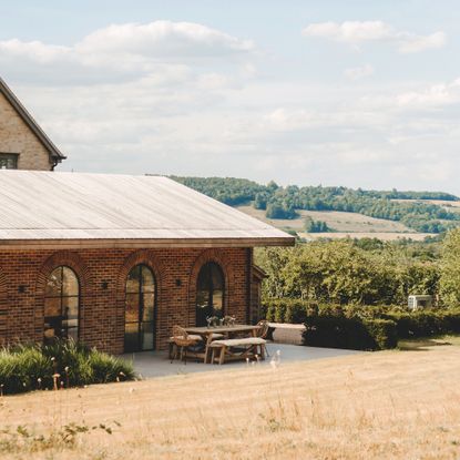 exterior of modern farmhouse with extension with arched patio doors