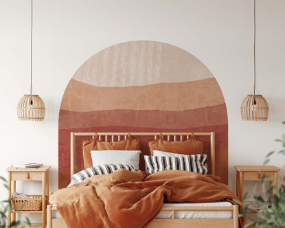 A boho arch desert decal behind a bed
