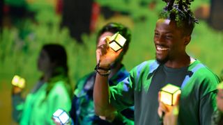 A man holding an Orb of Interaction that's glowing orange.