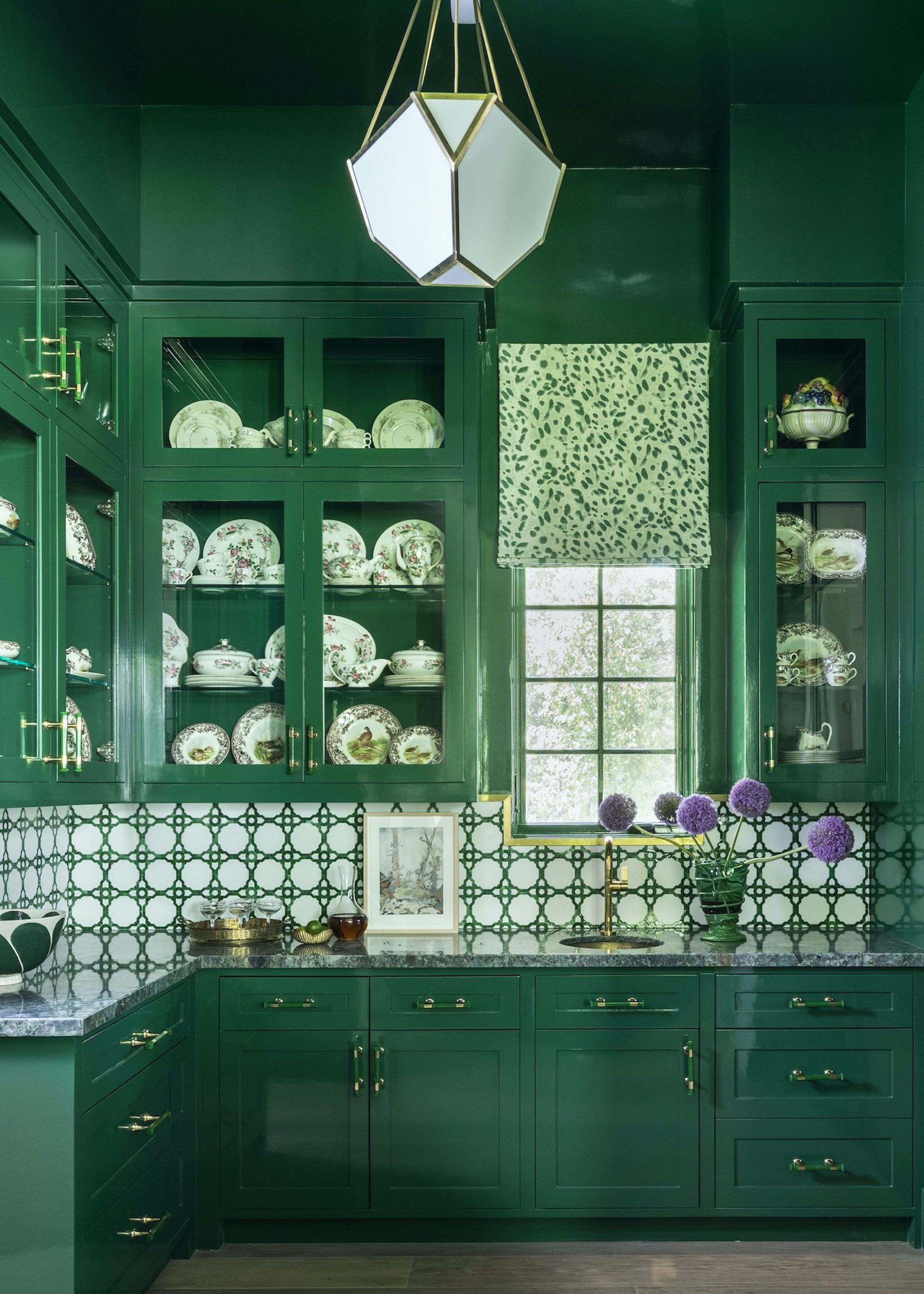 green kitchen with patterned tiles and glazed wall cabinets