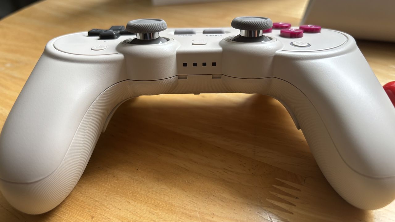 The 8BitDo Pro 3 controller photographed on a wooden table.