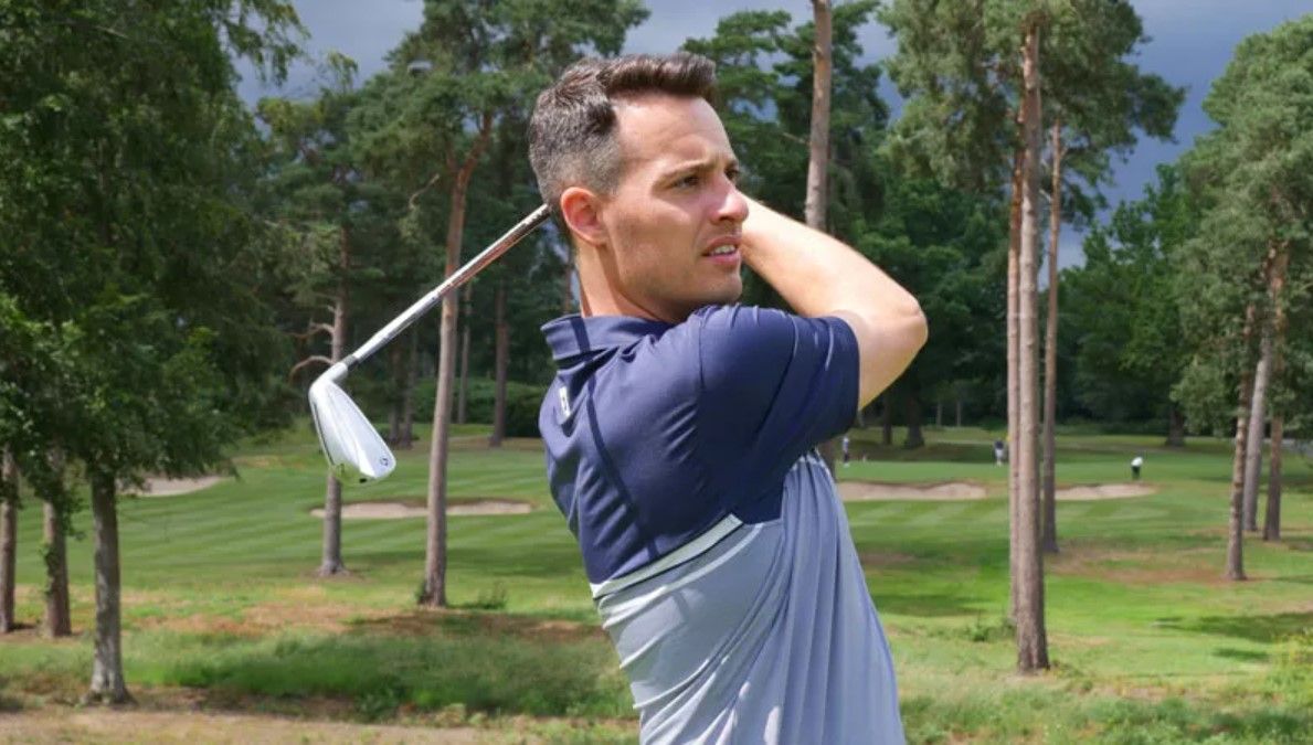 A golfer in a blue top hits the TaylorMade P790 golf irons