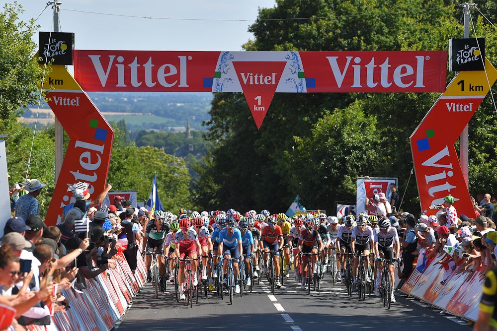 The bunch goes under the 1km banner during stage 6 at the Tour de France