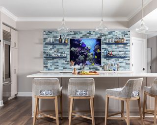 Neutral kitchen with backsplash on open wall, island and pendant lights