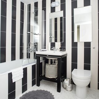 bathroom with black and white striped wall and bathtub