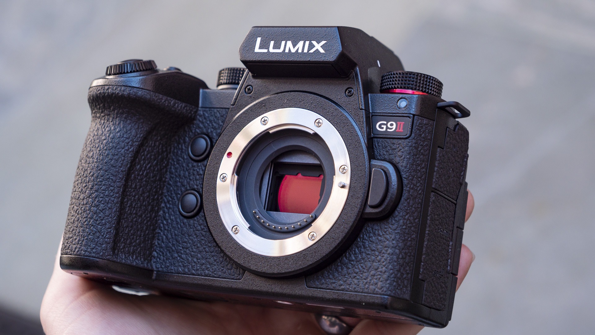 Panasonic Lumix G9 II in the hand with no lens attached and the sensor in view