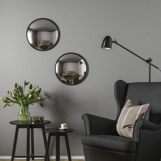 A living room with two convex mirrors hanging on the wall