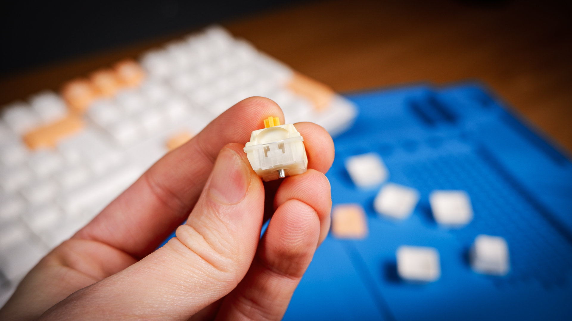 The Ducky One X induction gaming keyboard on a blue mat on a desk, with keycaps removed.