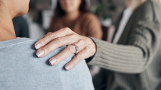 Woman with hand on friend's shoulder