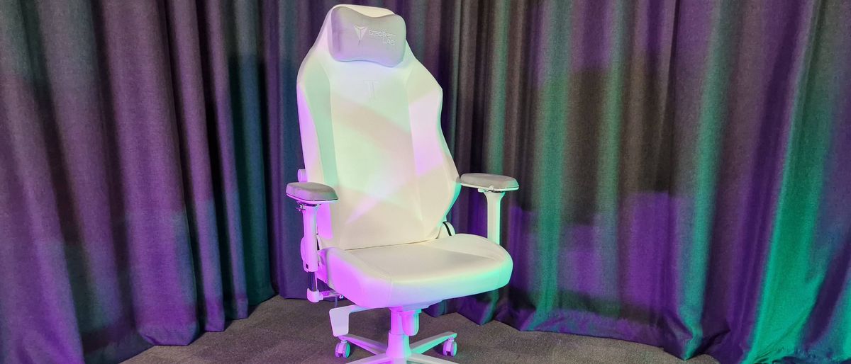 The Secretlab Titan Evo NanoGen Edition chair on a grey floor with grey curtains behind it