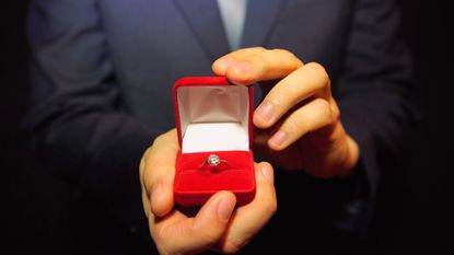A closeup of an engagement ring in its velvet box.
