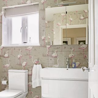 Bathroom with flamingo patterned wall paper and white basin