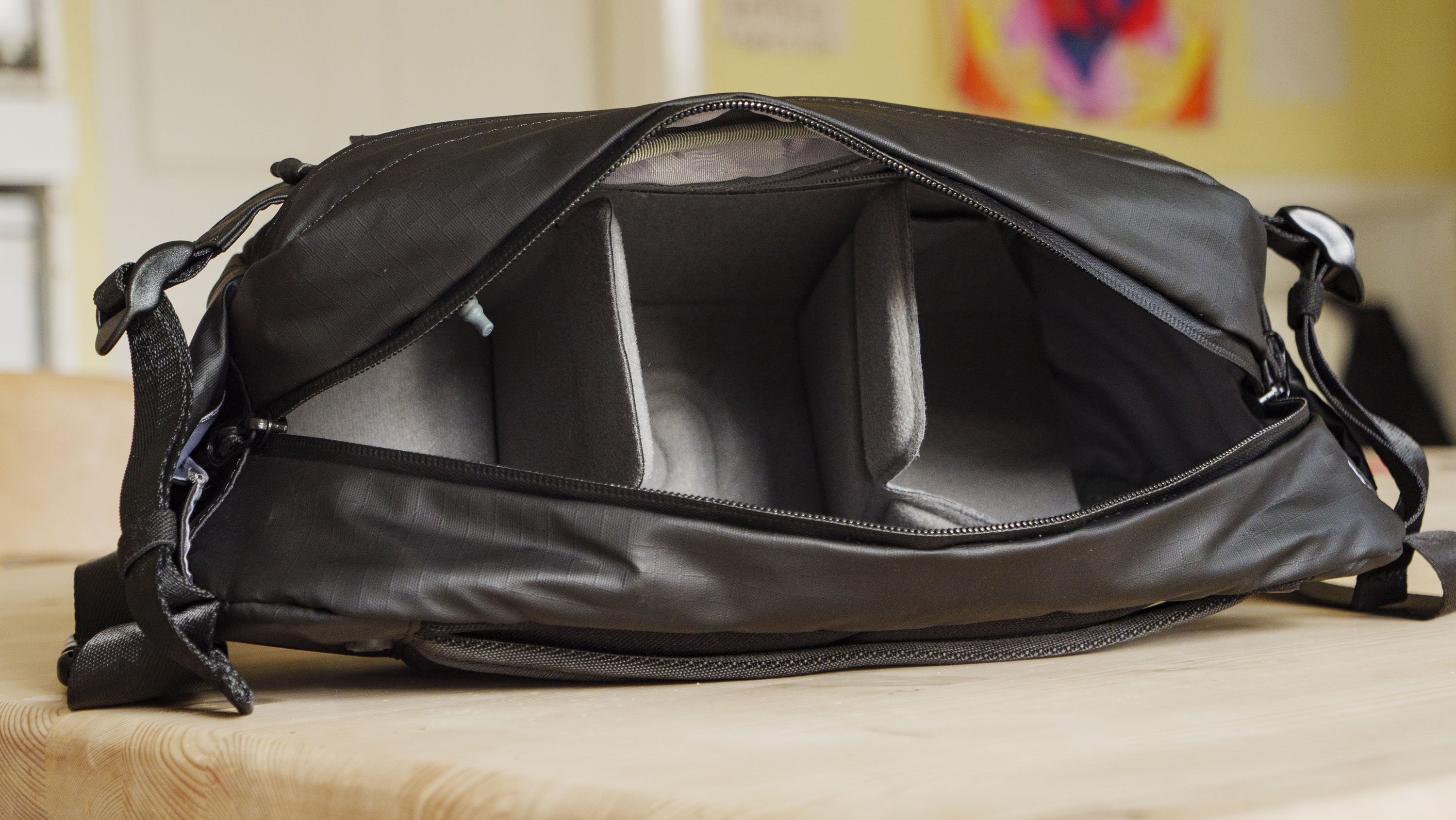 The Ulanzi Camera Sling Bag on a wooden table, main compartment open