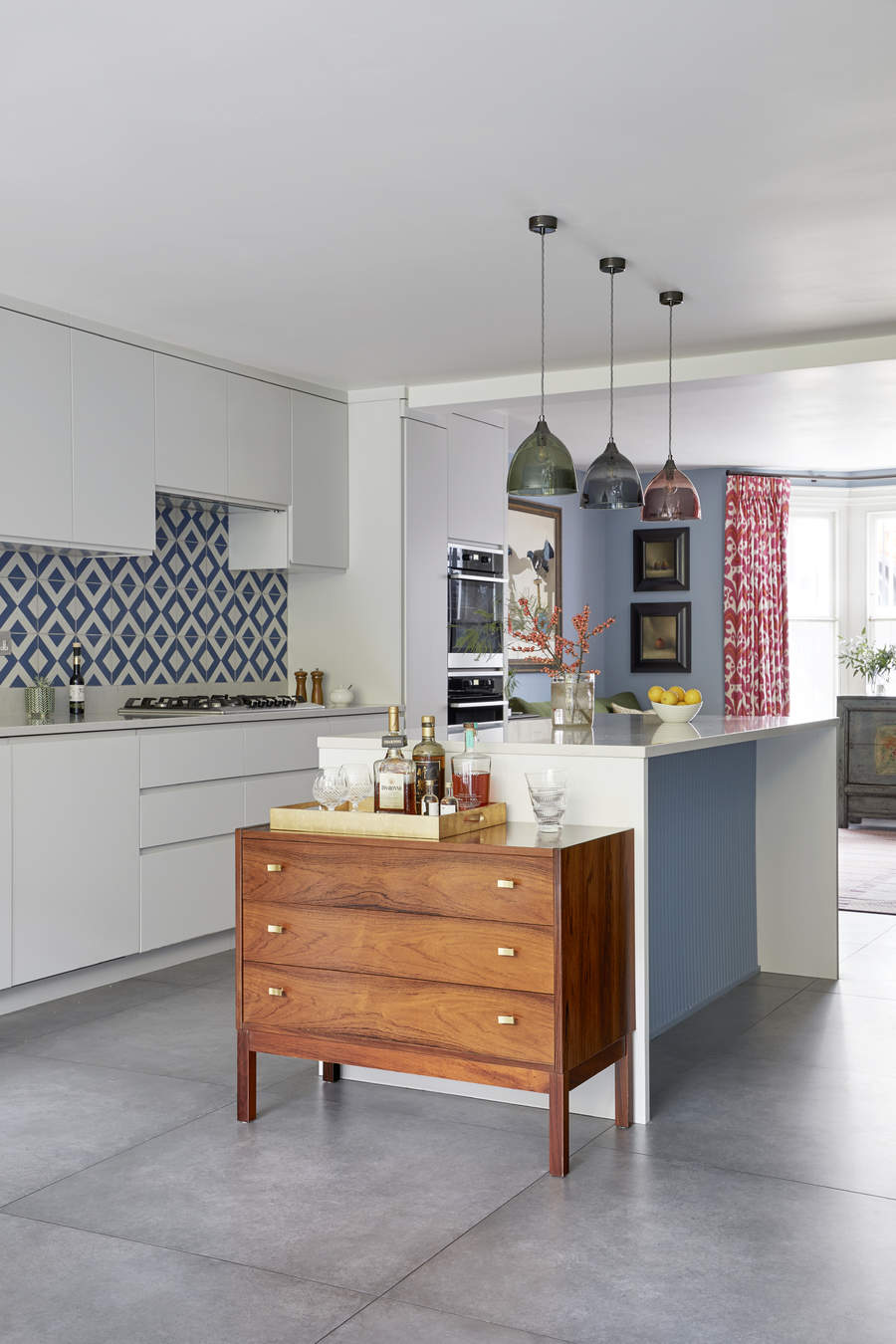 A kitchen with natural stone flooring and patterned backsplash