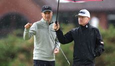 Jordan Spieth speaks to his coach under an umbrella