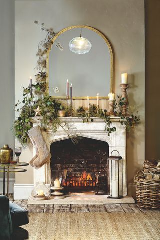Festive mantelpiece with stocking, mirror and greenery