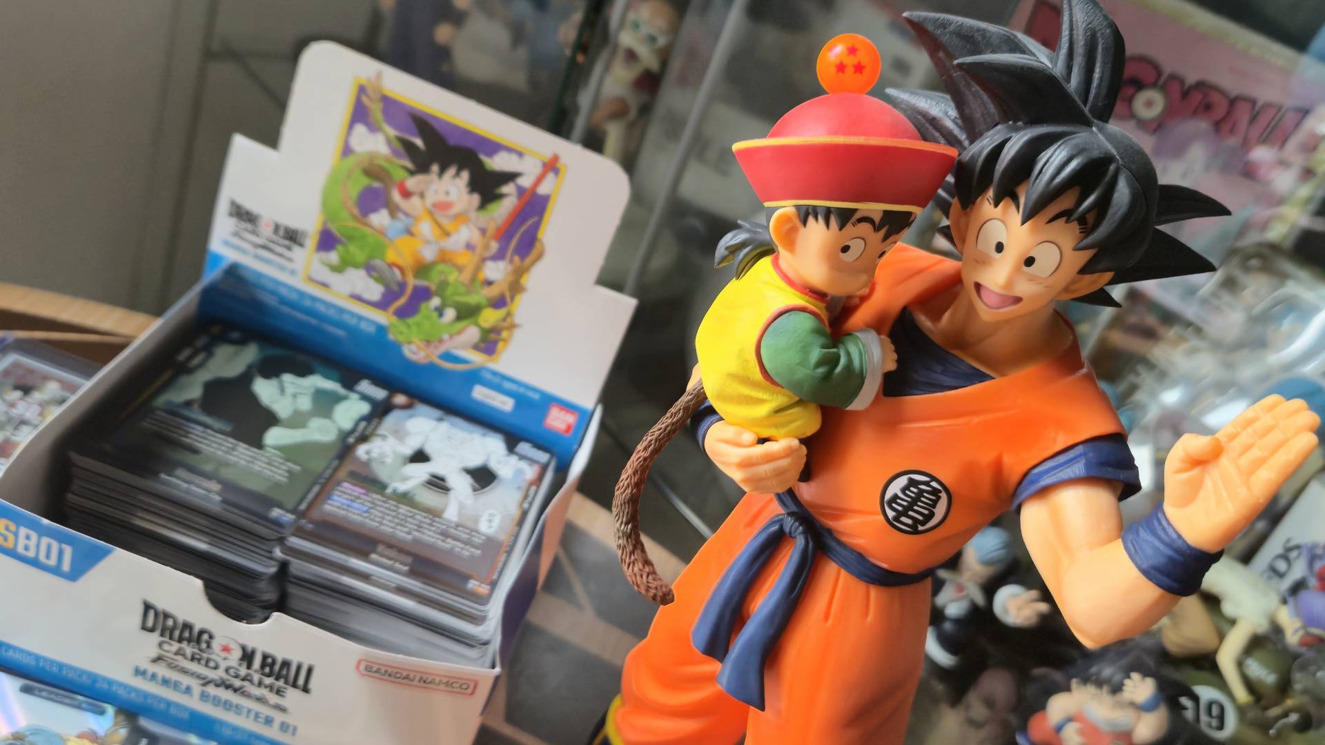 Photo by Rosalie Newcombe of a Goku figure stranding next to the Dragon Ball Super CG Fusion World - Manga Booster (SB01) box.