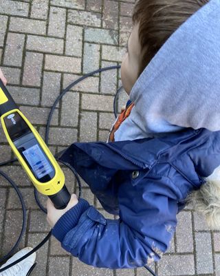 child helping with pressure washer
