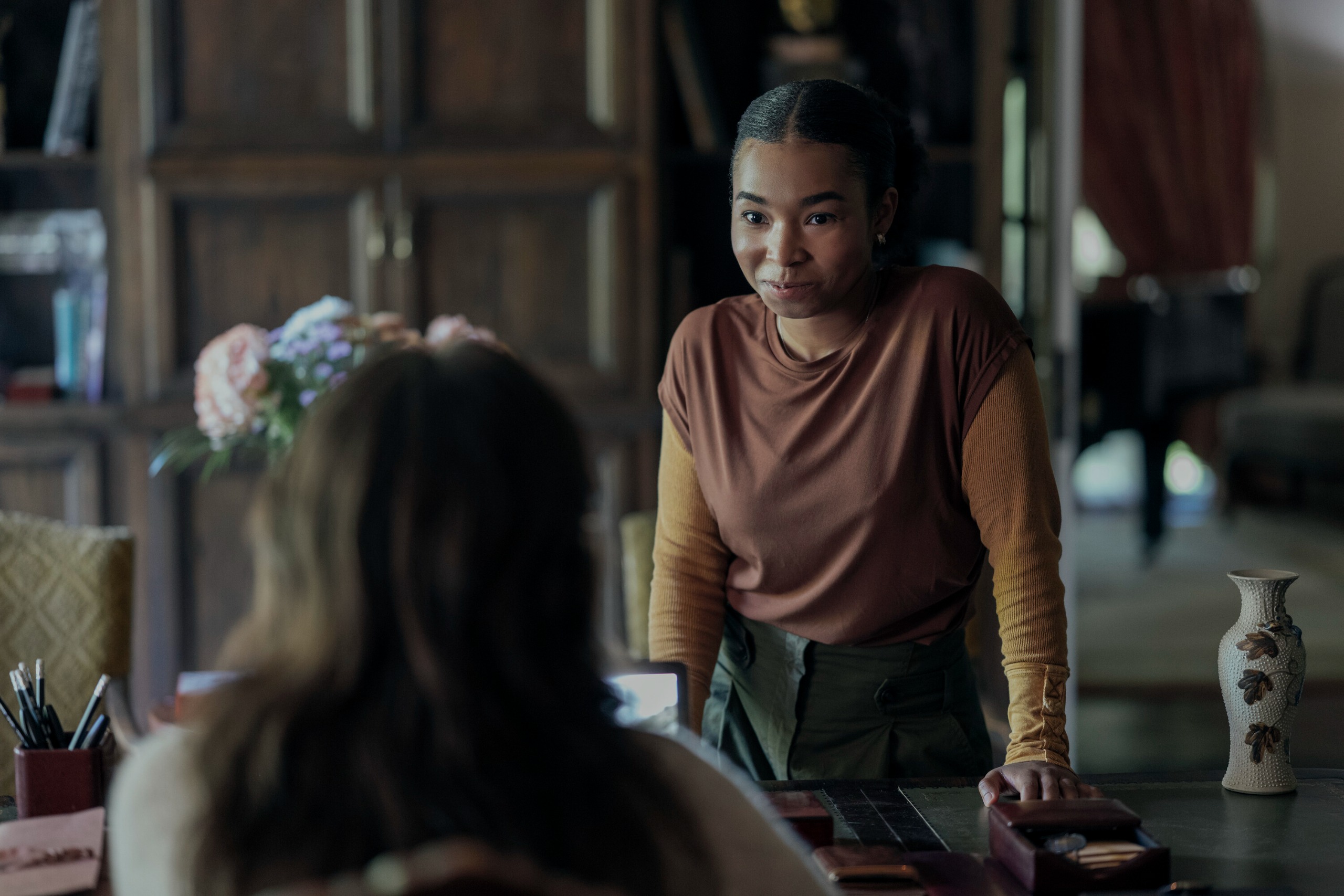 A young Black woman (Delainey Hayles) addresses an unseen woman behind a home-office desk, in Prime Video's 'Carrie.'