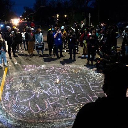 Night time protest for justice for Daunte Wright, chalk writing in the street
