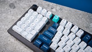 A black Keychron Q14 Max Alice keyboard with white, blue and teal keycaps