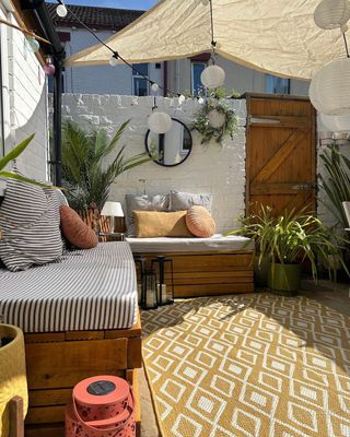 Outdoor courtyard with yellow rug and sofa