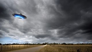 An illustration of a flying saucer above a country road.