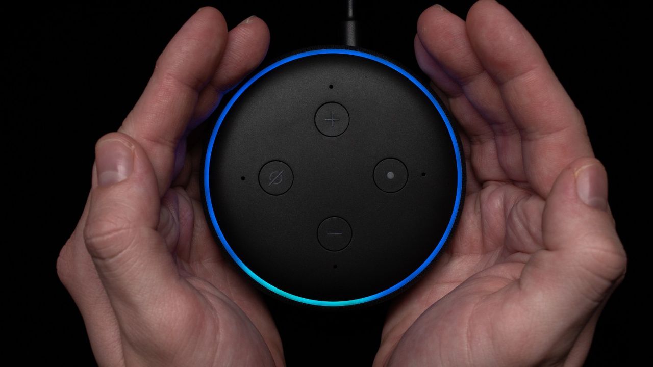 Two hands holding an Alexa device