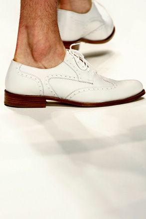 A man is wearing white color shoes.