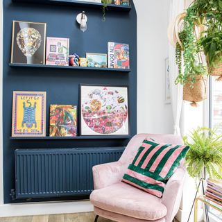 living room with books frames on navy shelves and hanging potted plants