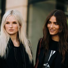 blonde and brunette women with shiny hair in a city 