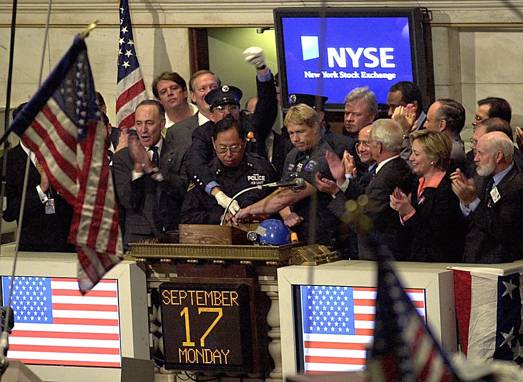 NYC Mayor Rudolph Giuliani, NY Gov. George Pataki, NY Sen. Hillary Clinton, firefighters and police officers ring the bell for the opening of the stock exchange on September 17, 2001.