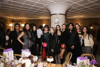 gloria steinem poses with a group of guests smiling at an event