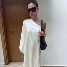 Influencer @iliridakrasniqi wears shield sunglasses with a white long-line blouse.