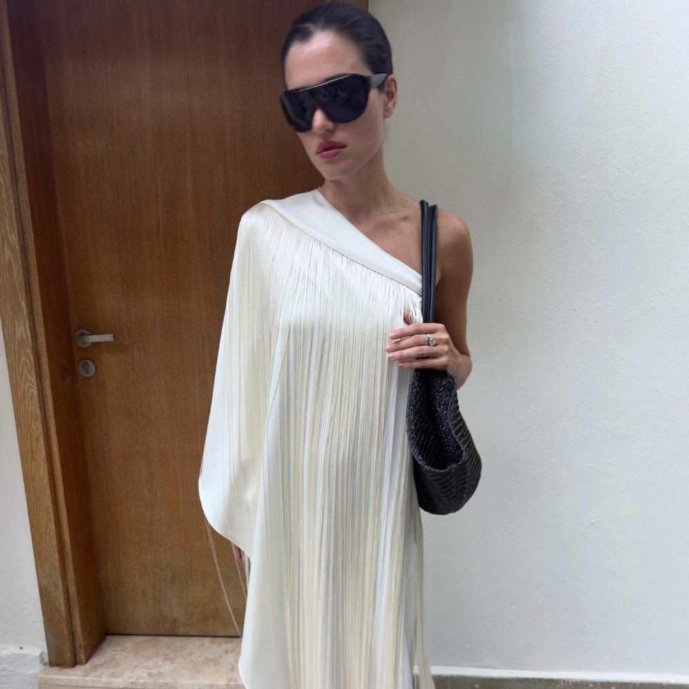Influencer @iliridakrasniqi wears shield sunglasses with a white long-line blouse.