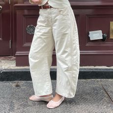 Anna Laplaca wearing barrel-leg jeans with white mesh flats.
