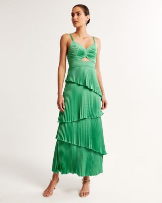 model wears green pleated satin dress with heeled sandals