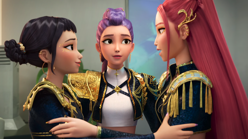 Zoey, Rumi and Mira embracing with black and gold costumes on in KPop Demon Hunters