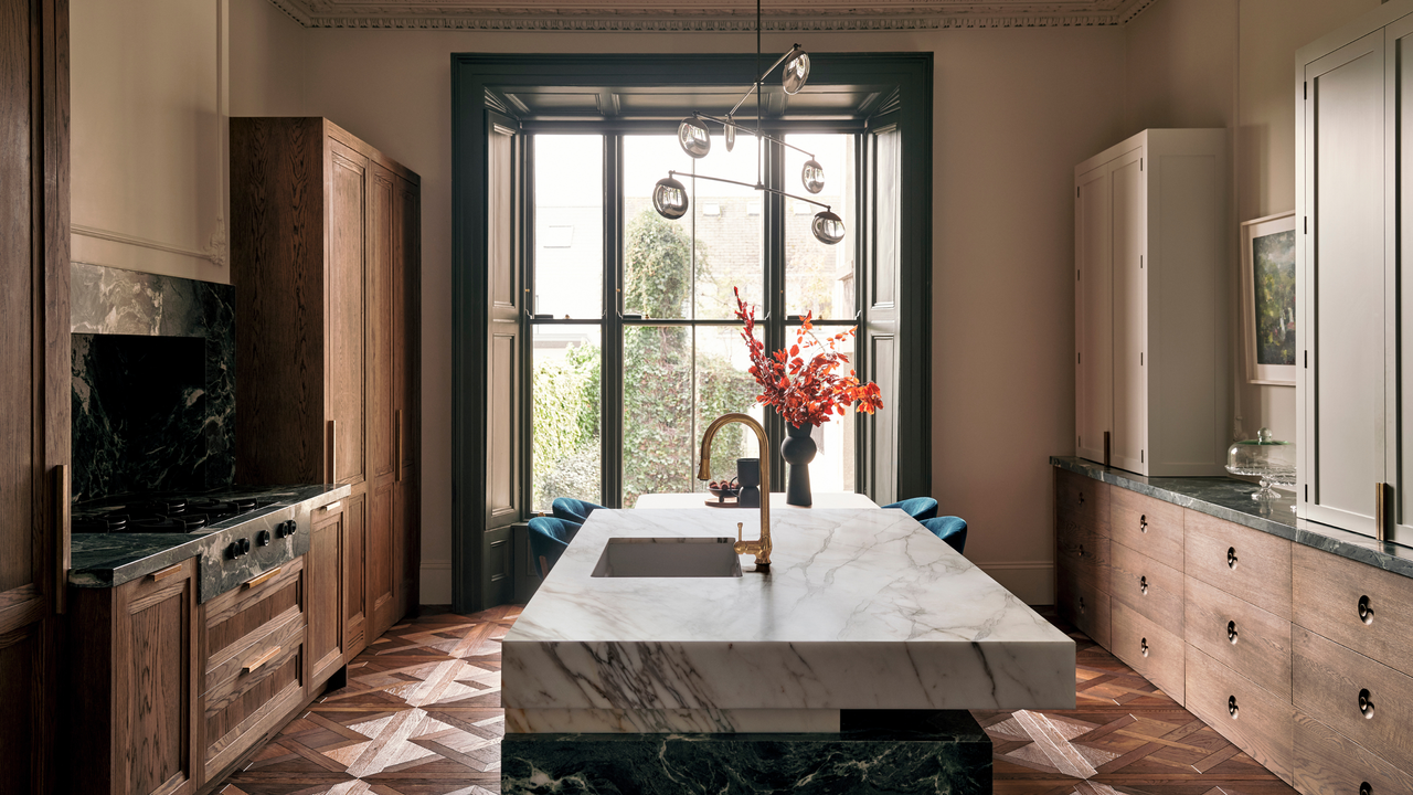 parquet floored kitchen with wooden cabinetry and a mixed marble kitchen island 
