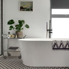 black and white bathroom with freestanding bath and black taps