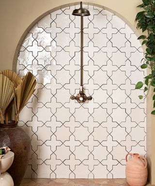A shower with an arched tile design